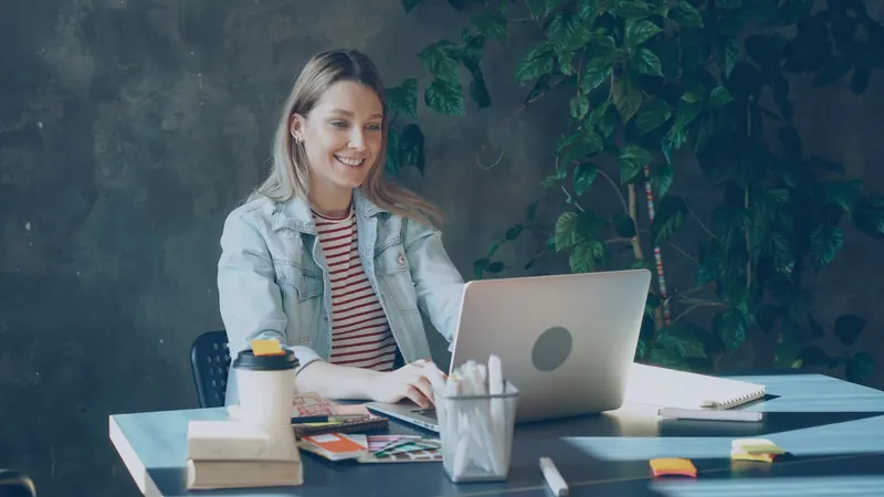 Une personne travaille sur un ordinateur portable, à son bureau