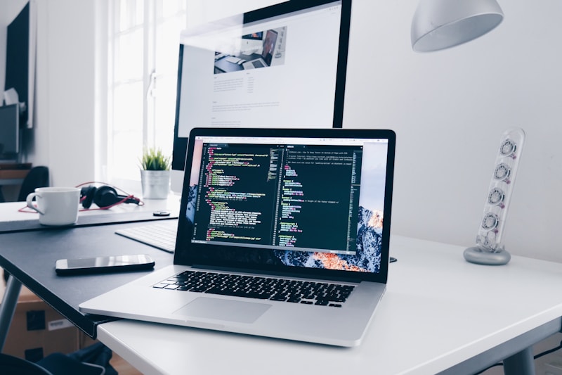 Développeur écrivant du code sur plusieurs écrans dans un environnement professionnel